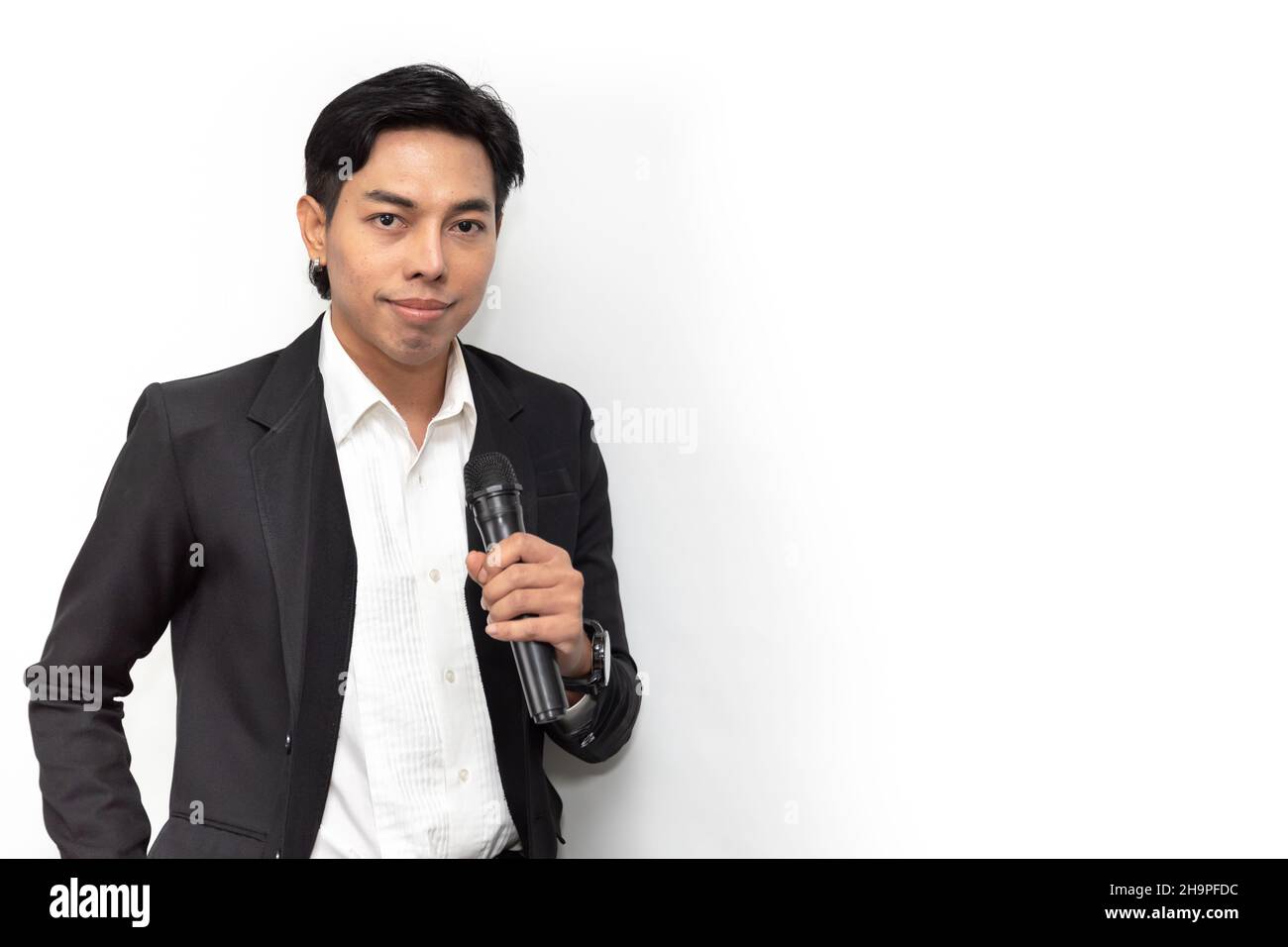 Portrait Asian male singer super star or presenter standing confident smile handle microphone isolated on white studio Stock Photo