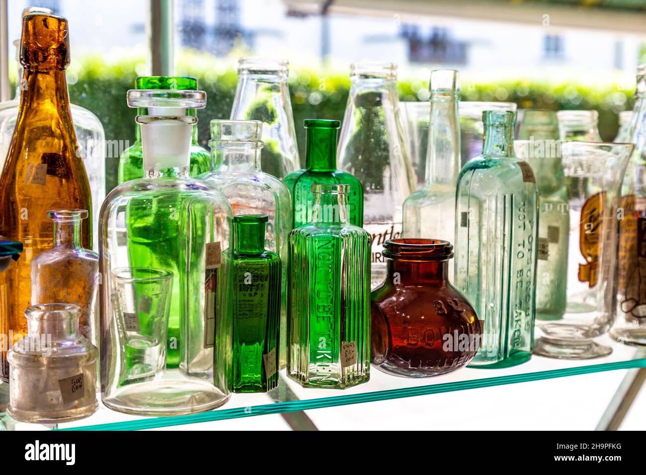 Vintage glass bottles on display at an antique shop (Hampton Court Emporium, East Molesay, UK) Stock Photo