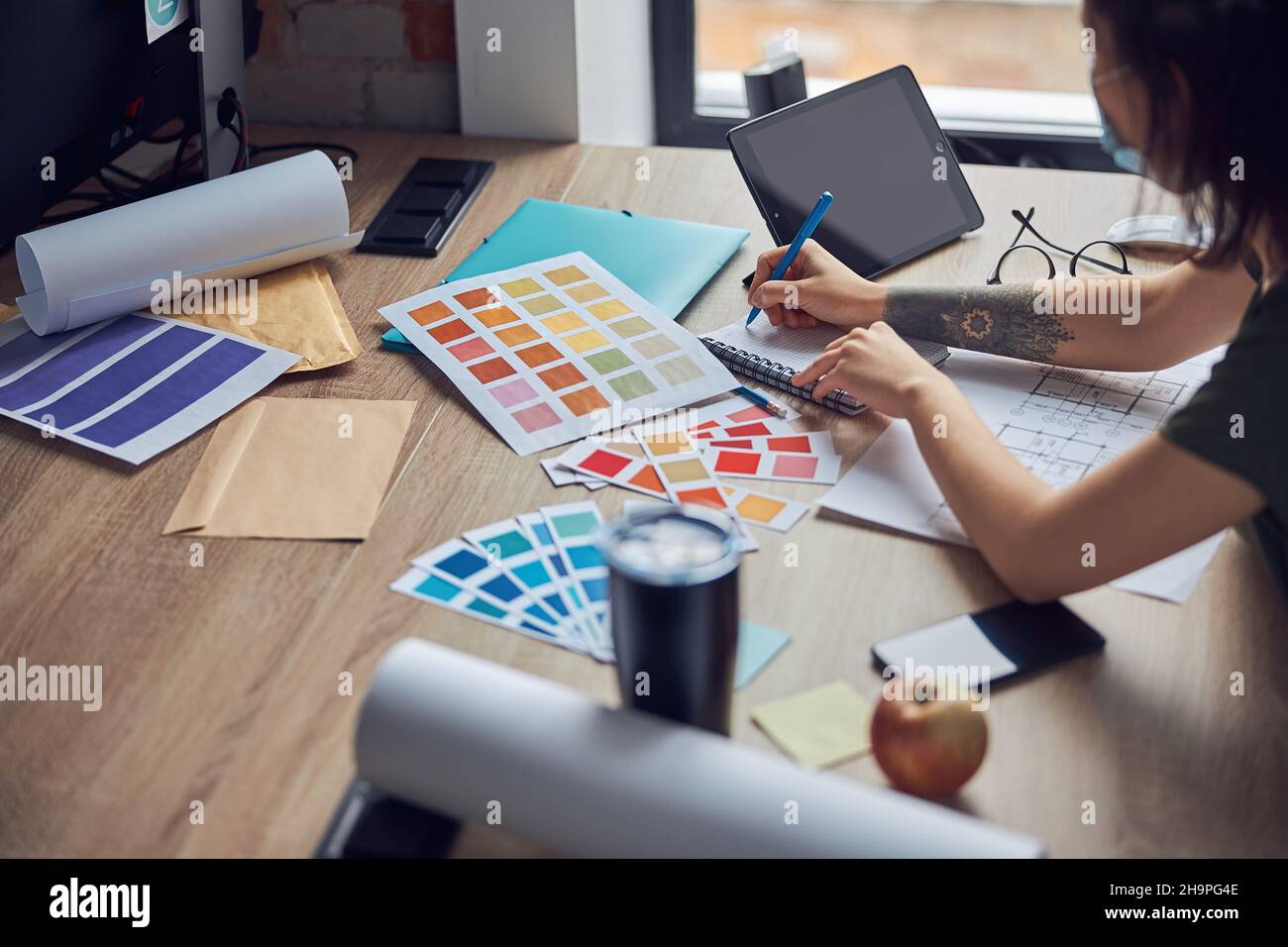 Close up shot of working process of interior designer making notes in ...
