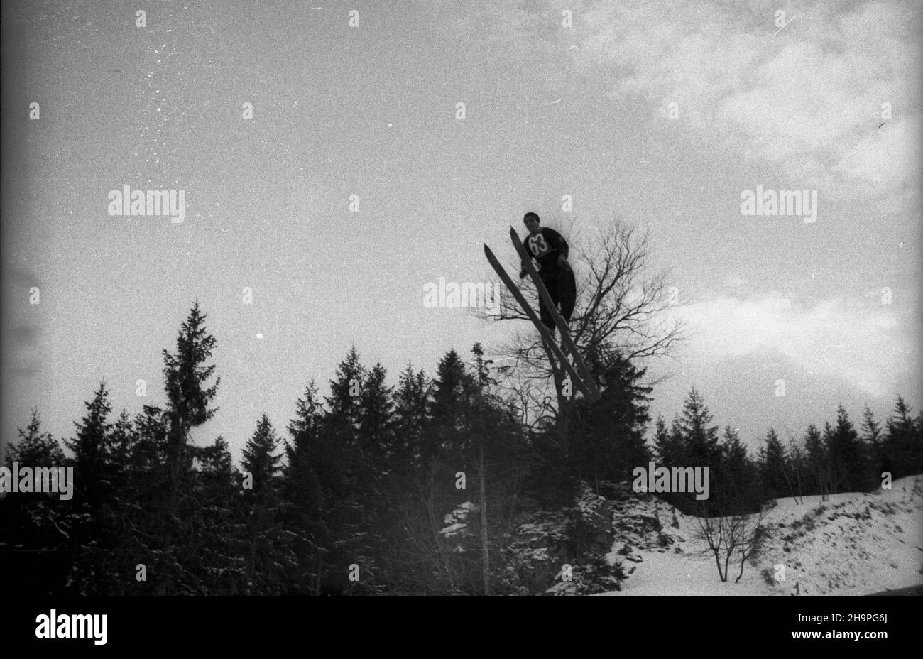 Zakopane, 1949-02-25. Od 23 lutego do 3 marca odbywa³y siê Miêdzynarodowe Zawody Narciarskie o Puchar Tatr. Zgromadzi³y one kilkudziesiêciu sportowców z Polski, Bu³garii, Czechos³owacji, Finlandii, Rumunii i Wêgier. Drugiego dnia zawodów odby³ siê konkurs skoków na Wielkiej Krokwi, zaliczanych do kombinacji norweskiej. Nz. skacze w trzeciej serii Franek Tadeusz G¹sienica z Polski. pw PAP Zakopane, Feb. 25, 1949. International Skiing Competition for the Cup of the Tatra Mountains was held on February 23 to March 3. The competition brought together several dozen sportsmen from Poland, Bul Stock Photo