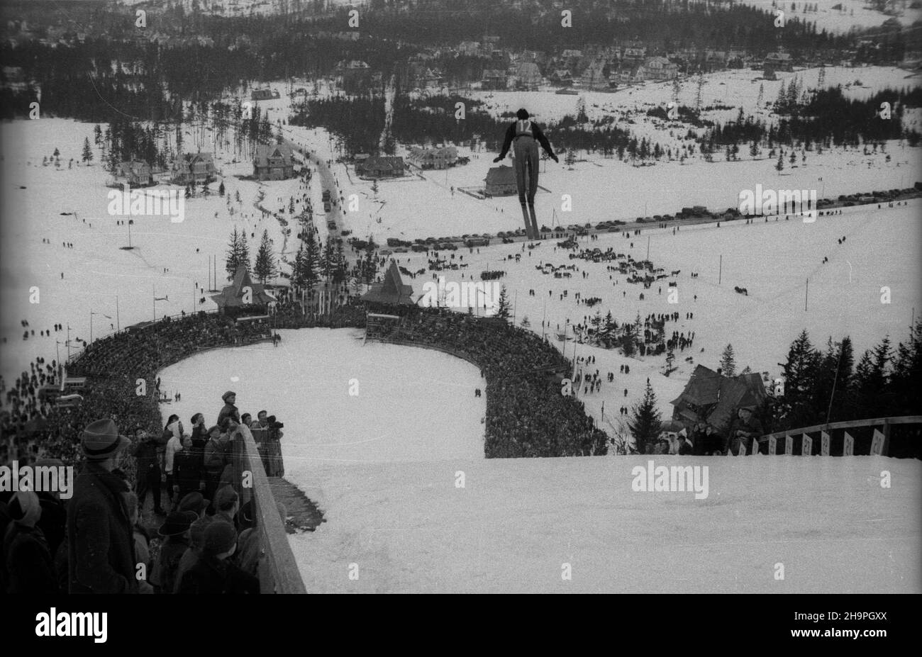 Zakopane, 1949-02-25. W Miêdzynarodowych Zawodach Narciarskich o Puchar Tatr wziê³o udzia³ przesz³o 250 zawodników i zawodniczek reprezentuj¹cych szeœæ pañstw: Czechos³owacjê, Wêgry, Rumuniê, Bu³gariê, Finlandiê i Polskê. Otwarty konkurs skoków obejrza³o na stadionie PZN (Polski Zwi¹zek Narciarski) pod Krokwi¹ dwadzieœcia tysiêcy widzów. uu PAP Zakopane, Feb. 25, 1949. The Tatra Mountain Cup International Skiing Competition brought together over 250 competitors from 6 countries: Czechoslovakia, Hungary, Romania, Bulgaria, Finland and Poland. A ski jump event was watched by 20,000 people Stock Photo