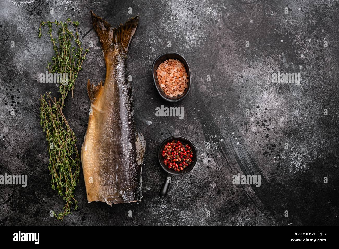 Smoked whole trout, on black dark stone table background, top view flat ...