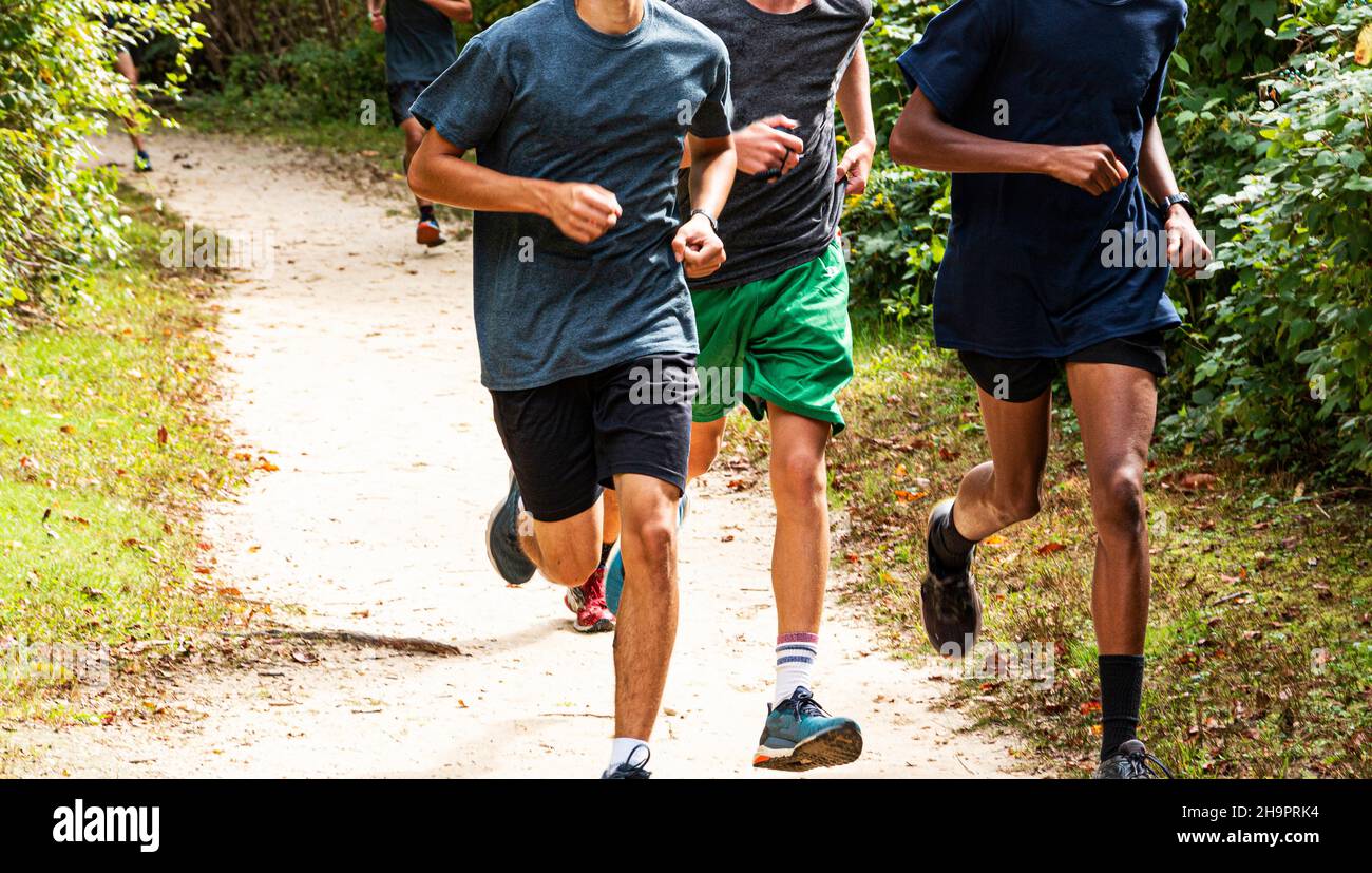 Front view of high school boys cross country team running together on a ...