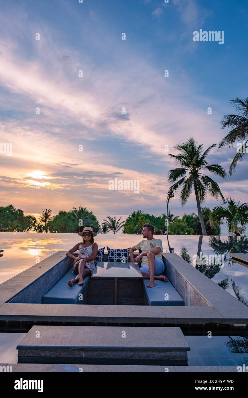 couple watching the sunset in an infinity pool on a luxury vacation in ...