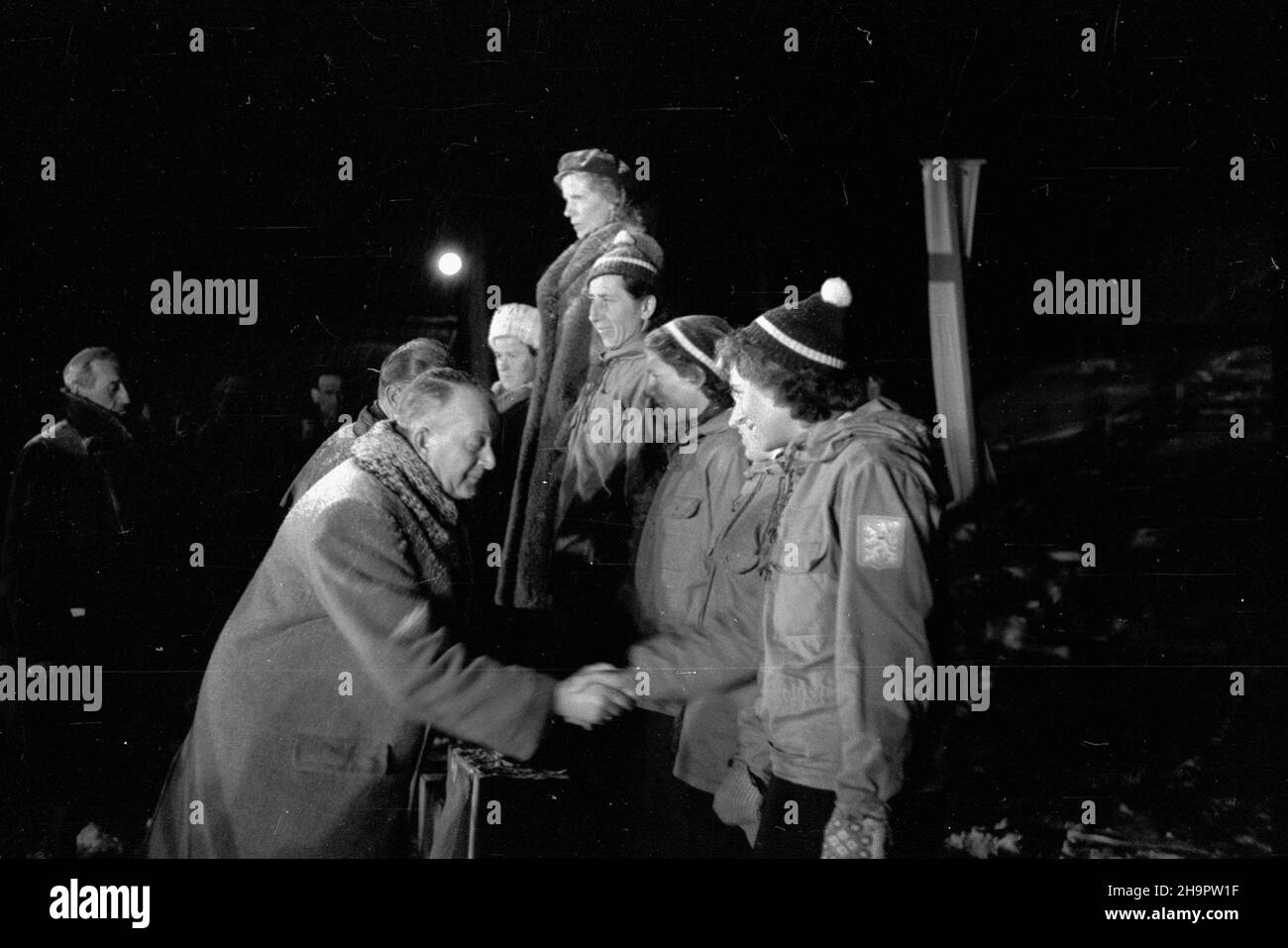 Zakopane, 1949-03-03. Miêdzynarodowe Zawody Narciarskie o Puchar Tatr (23 II-3 III). Uroczystoœæ zakoñczenia turnieju na stadionie sportowym pod Krokwi¹. Nz. wiceprezes Polskiego Zwi¹zku Narciarskiego Aleksander Boniecki gratuluje najlepszym zawodniczekom w konkurecji biegu na 8 km, od lewej: Finka Inkeri Korjus (II miejsce), Finka Maire Saloranta (I miejsce), Czeszki: Lelkova (III miejsce), Beinhauerova (IV miejsce) i Weisshautelova (V miejsce). ka PAP Zakopane, March 3, 1949. The International Skiing Tournement for the Tatra Mountains Cup (February 23 -March 3). The ceremony winding up Stock Photo