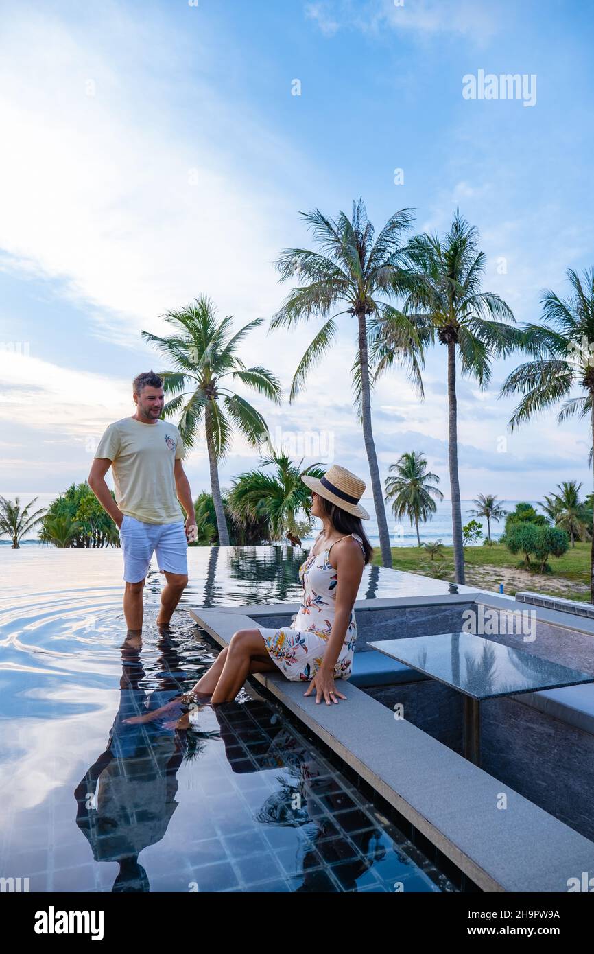 couple watching the sunset in an infinity pool on a luxury vacation in ...