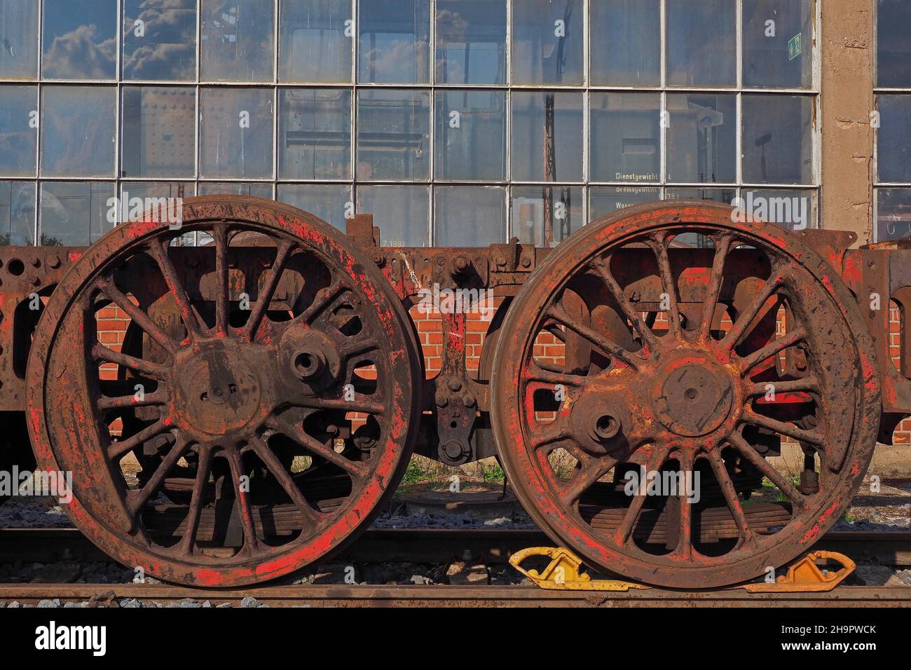 Railway wheels in front of factory hall, locomotive shed, workshop hall, steam locomotive, view into locomotive shed, old railway station Stock Photo