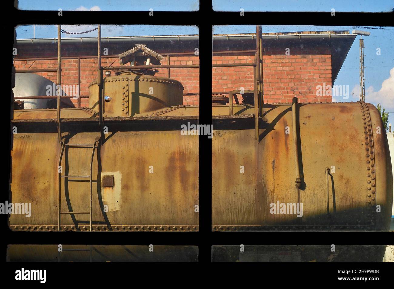 View through factory window on diesel tank at station, workshop hall, steam locomotive, view from locomotive shed, old station Hanau-Grossauheim Stock Photo