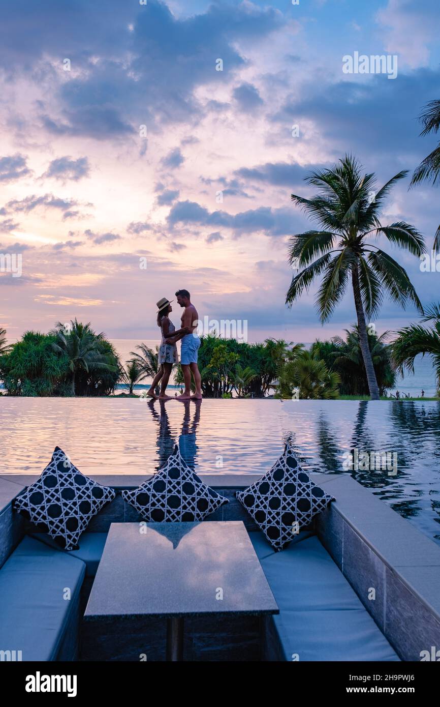 couple watching the sunset in an infinity pool on a luxury vacation in ...