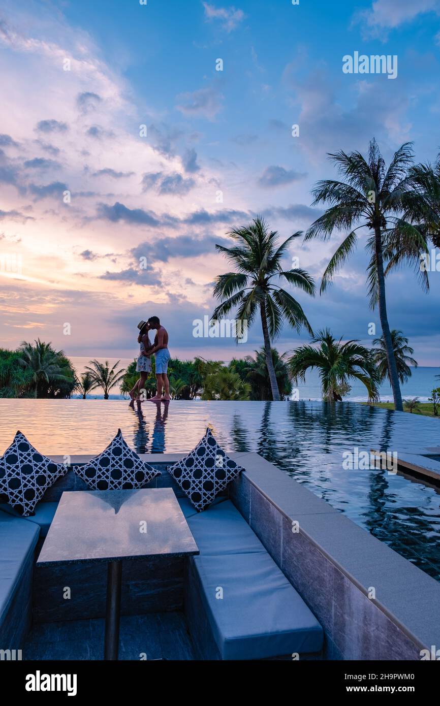 couple watching the sunset in an infinity pool on a luxury vacation in ...