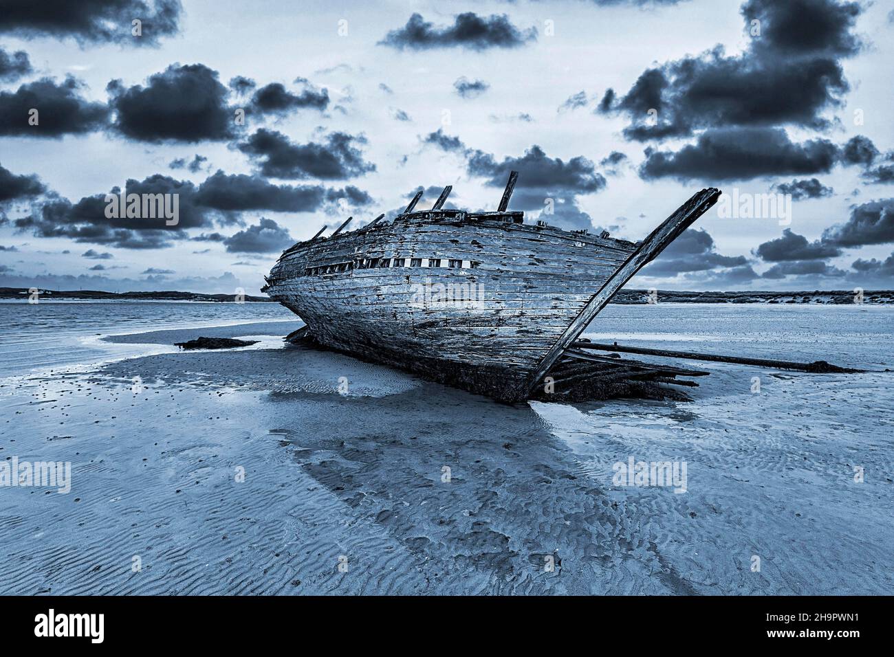 Wooden Shipwreck Bad Eddies Boat at Low Tide, Evening Sky, Bunbeg, Magheraclogher Beach, Gweedore, Donegal, Ireland Stock Photo