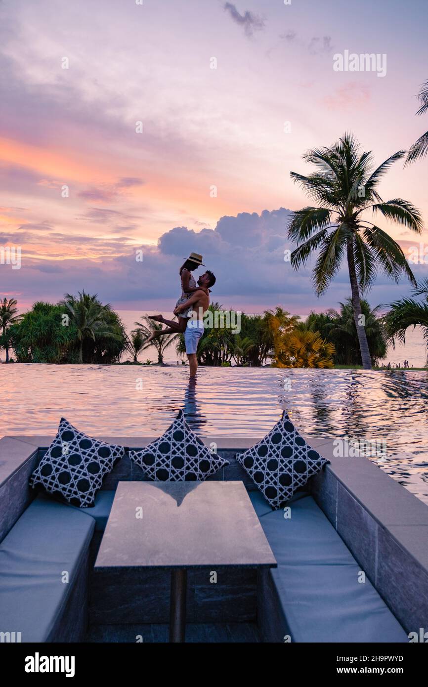 couple watching the sunset in an infinity pool on a luxury vacation in ...