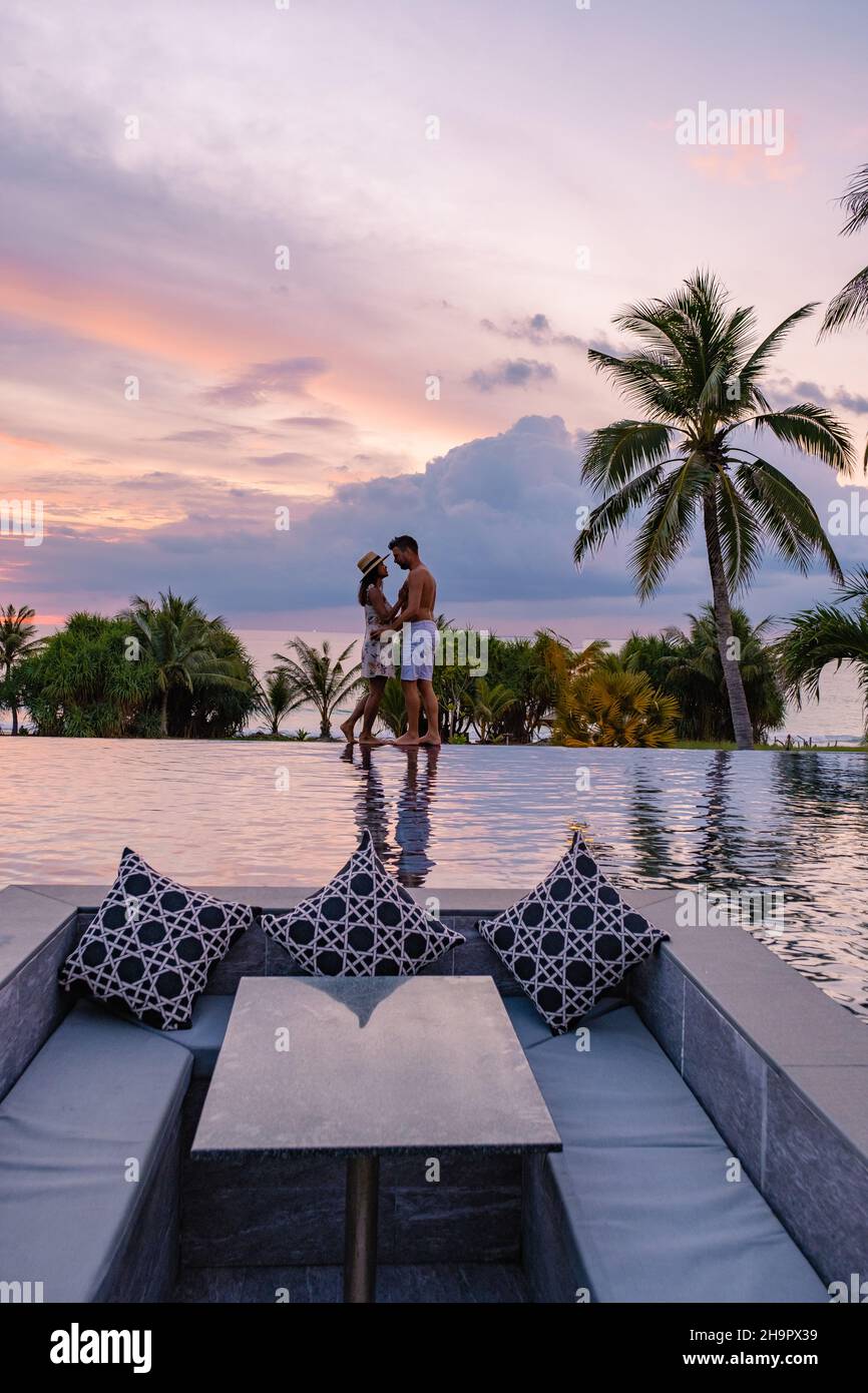 couple watching the sunset in an infinity pool on a luxury vacation in ...