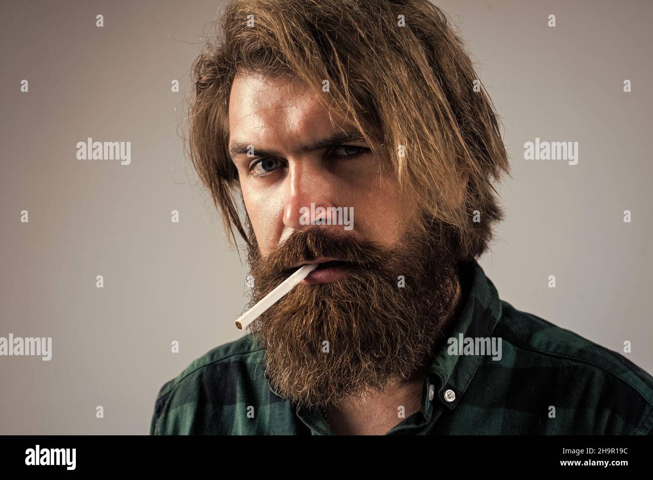 he is on smoke break. smoking concept. mature brutal hipster in checkered  shirt. casual fashion style. bearded man holding cigarette. harmful bad  Stock Photo - Alamy
