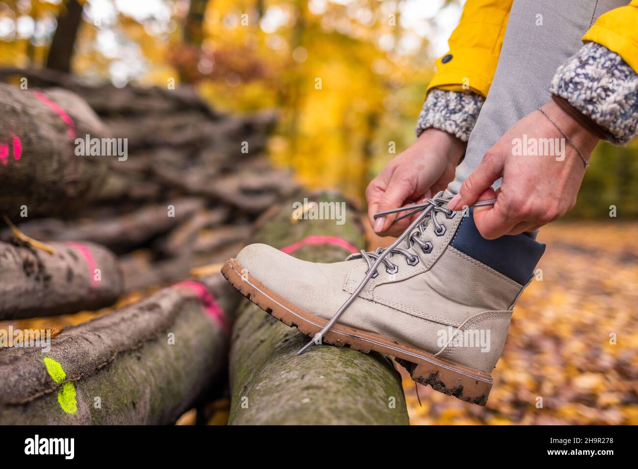 Woman tying shoelace on her hiking boot. Tourist is getting ready for