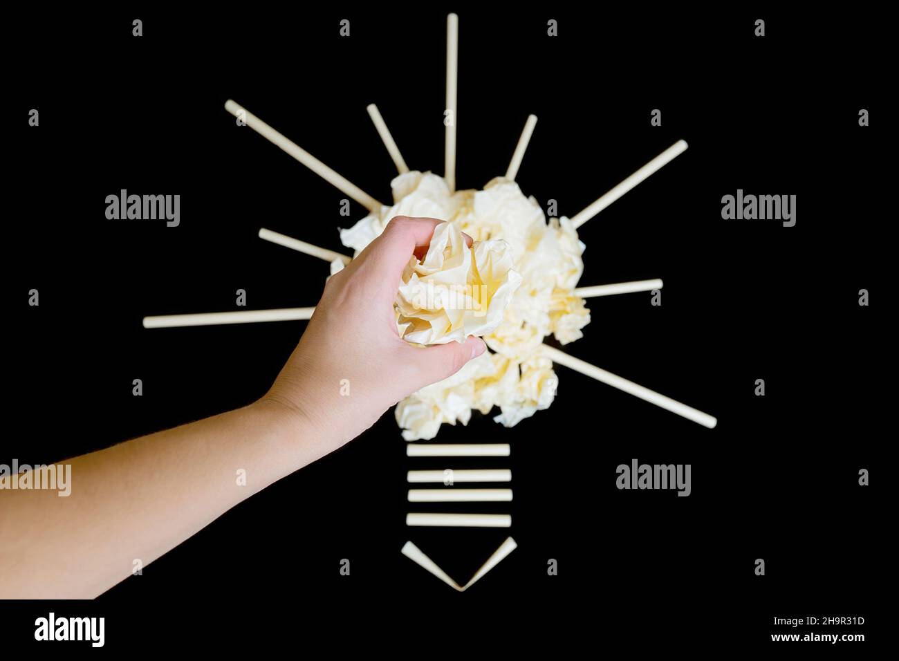 Light bulb shape made from crumpled paper balls on a black background ...