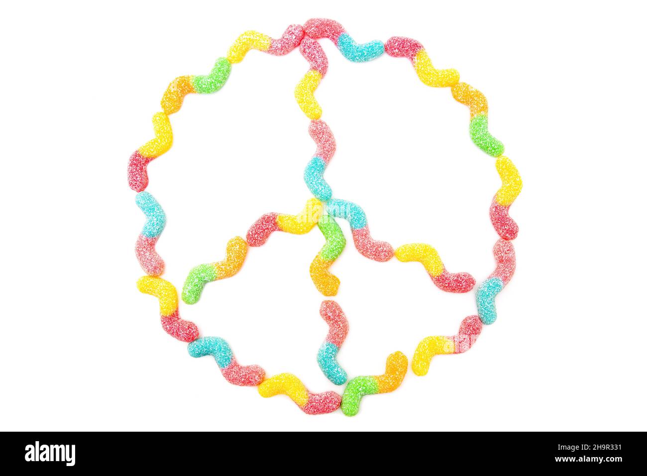Peace sign made from multicolored sugar coated gummy worms isolated on white. Anti-war symbol. Stock Photo