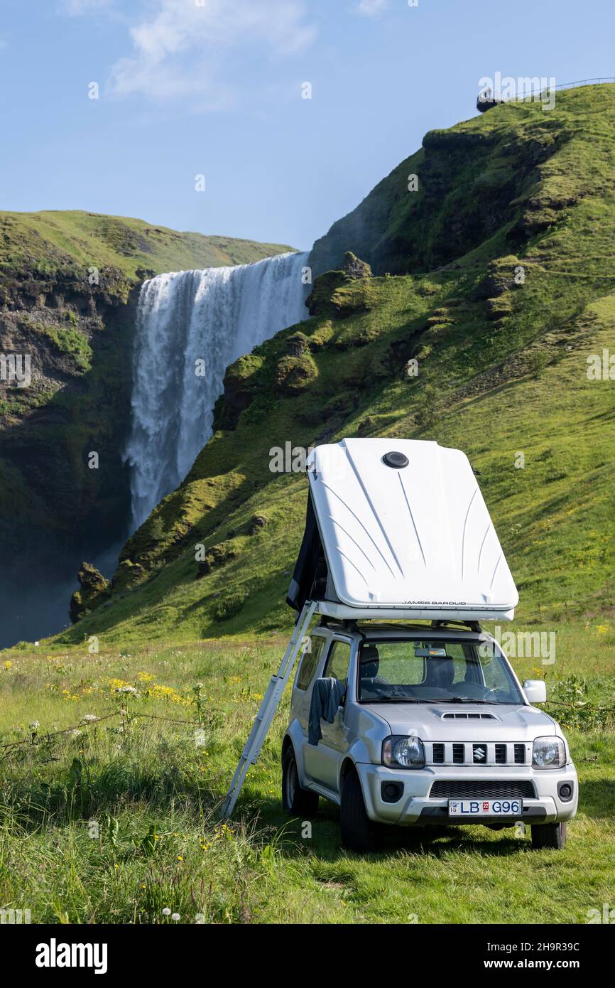 Car with roof tent, camping site, Skogafoss waterfall in summer when