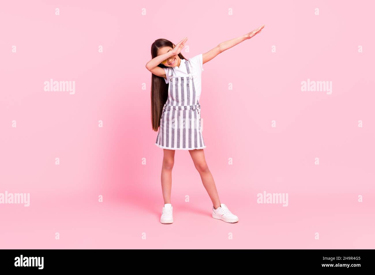 full length body size photo schoolgirl overall showing dab sign dancing isolated pastel pink color background 2H9R4G5