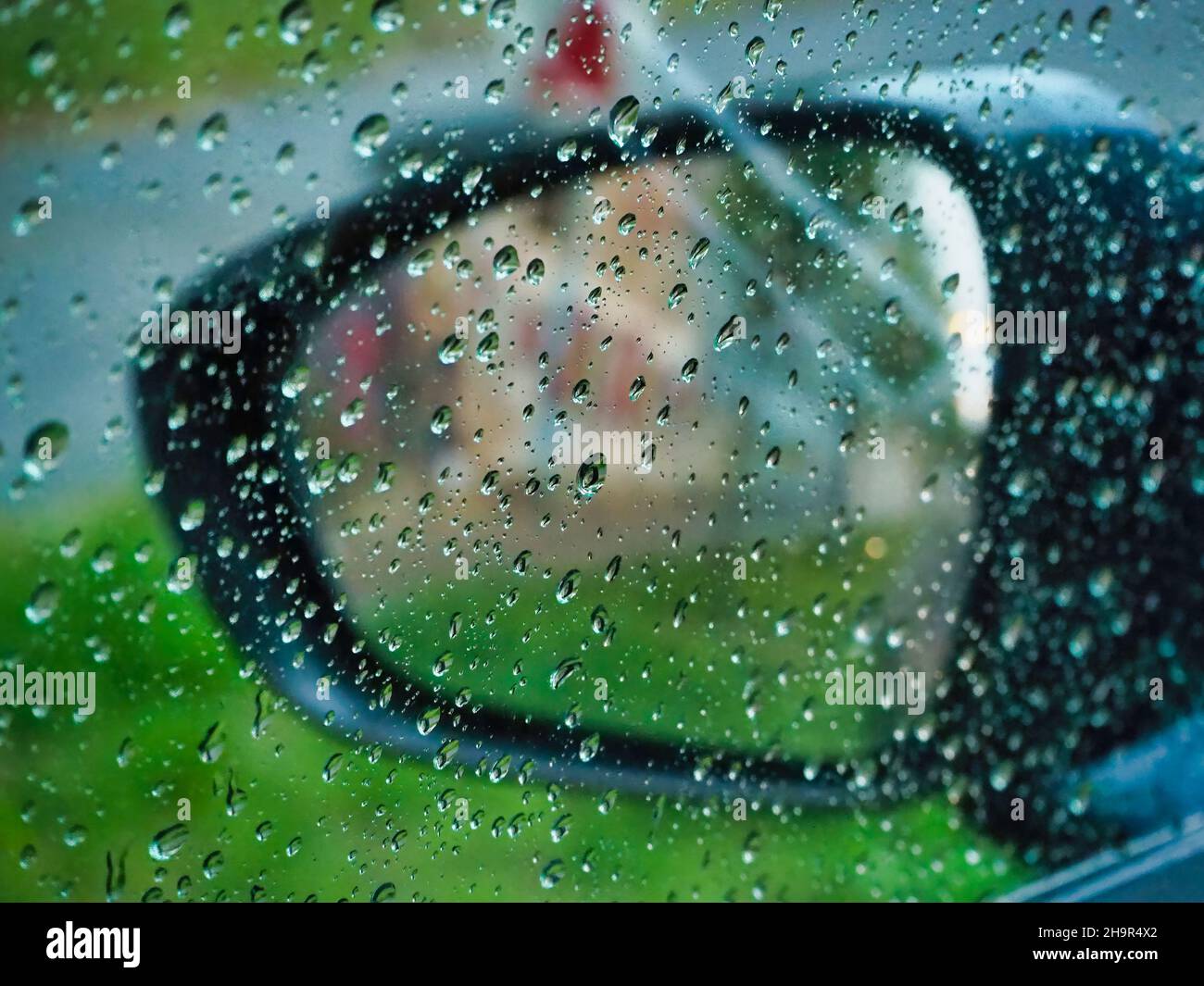 Rainy day view out the car window with water droplets on the glass ...
