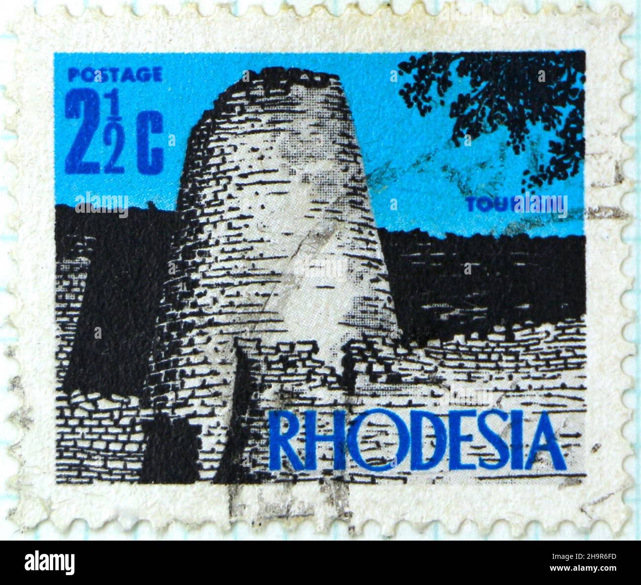 Photo of a 2 1/2c Rhodesian Postage stamp with an illustration of the conical tower in the ancient ruins of the Great Zimbabwe monument Stock Photo