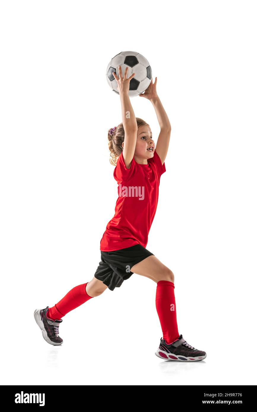 Fulllength portrait of little girl, football player training, throwing