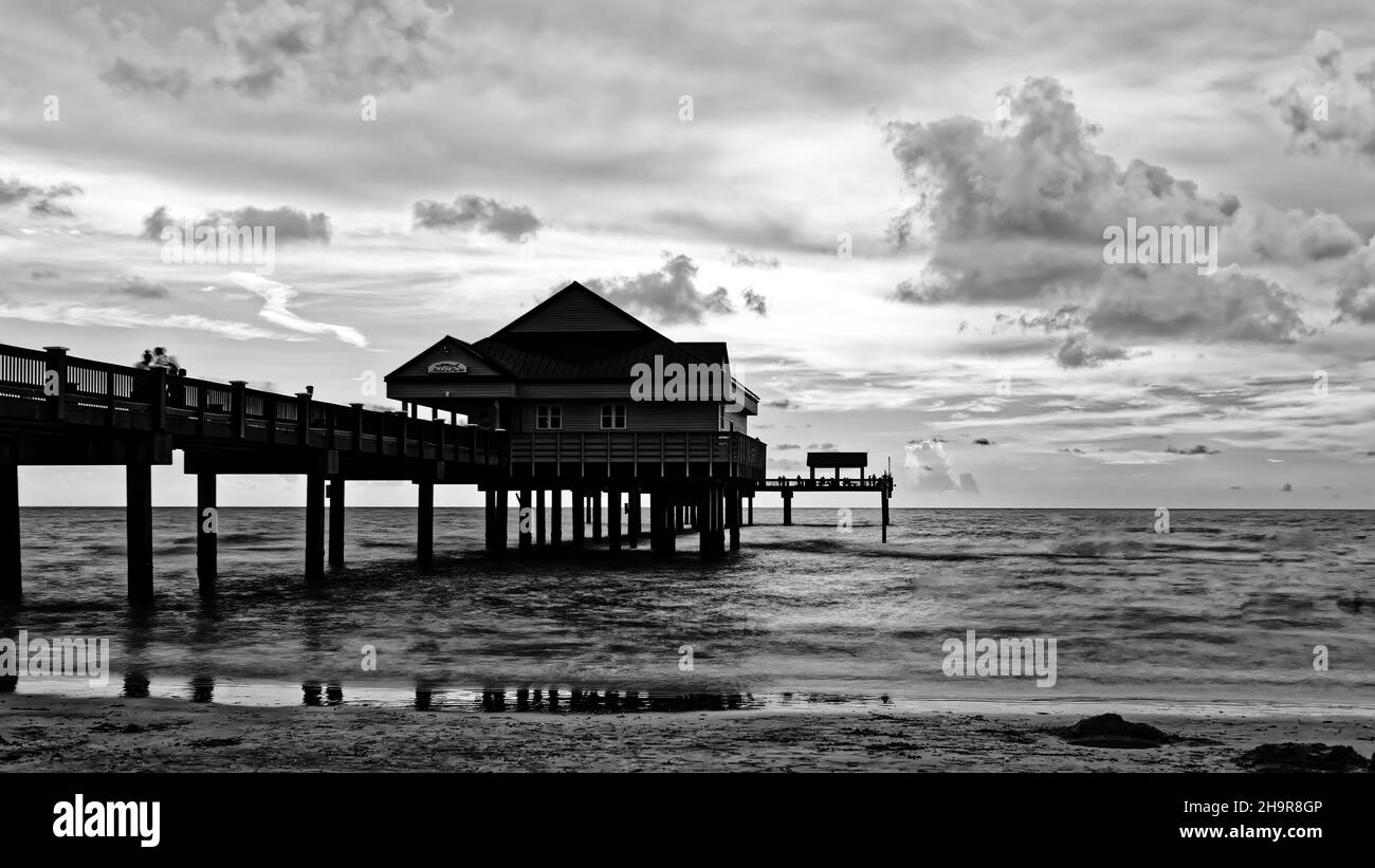 Grayscale shot of an exotic wooden hut on the beach Stock Photo