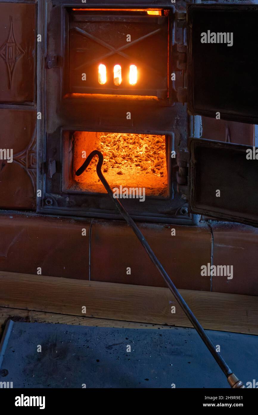 Indoor coal fired furnace in teh apartment of an old tenement house, at fullblaze, on a cold winter day. Stock Photo