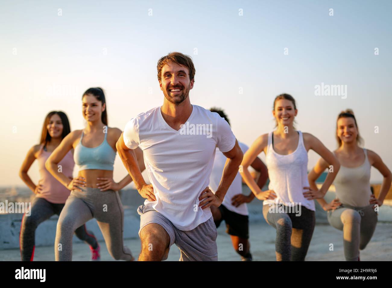 Group of happy fit friends exercising together outdoors. Sport people healthy lifestyle concept Stock Photo