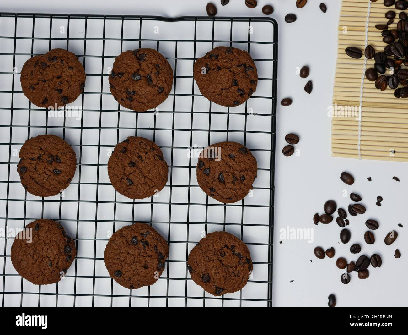 chocolate chip cookies on a grill with coffee beans on a white