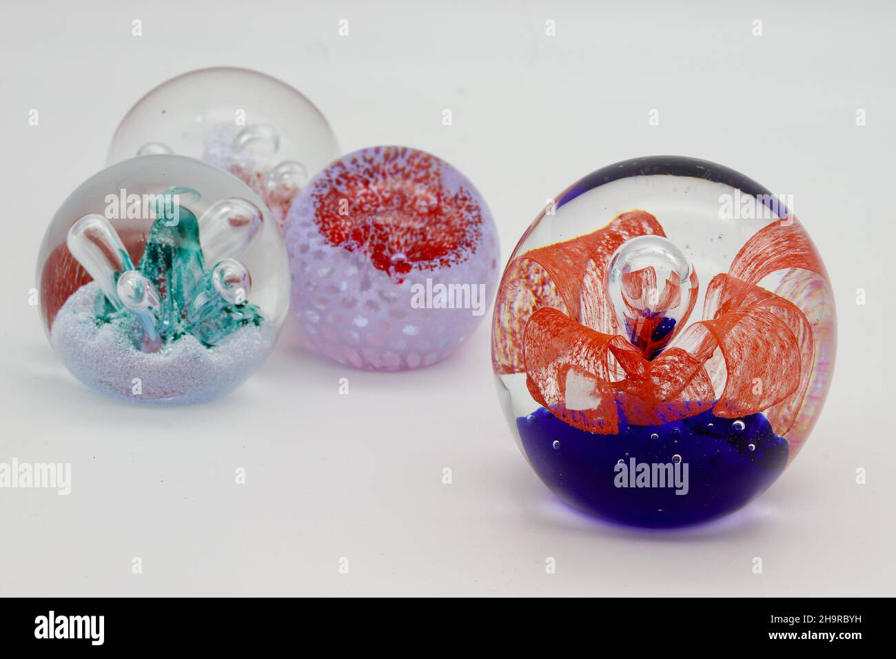 Ipswich, UK December 2021 Paperweight collection. Four multi coloured items Stock Photo Alamy