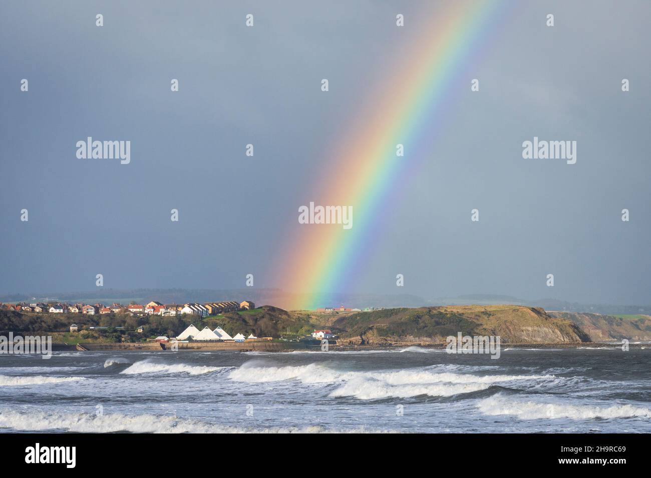 Autumn showers and a rainbow over Scarborough north bay, North Yorkshire UK Stock Photo