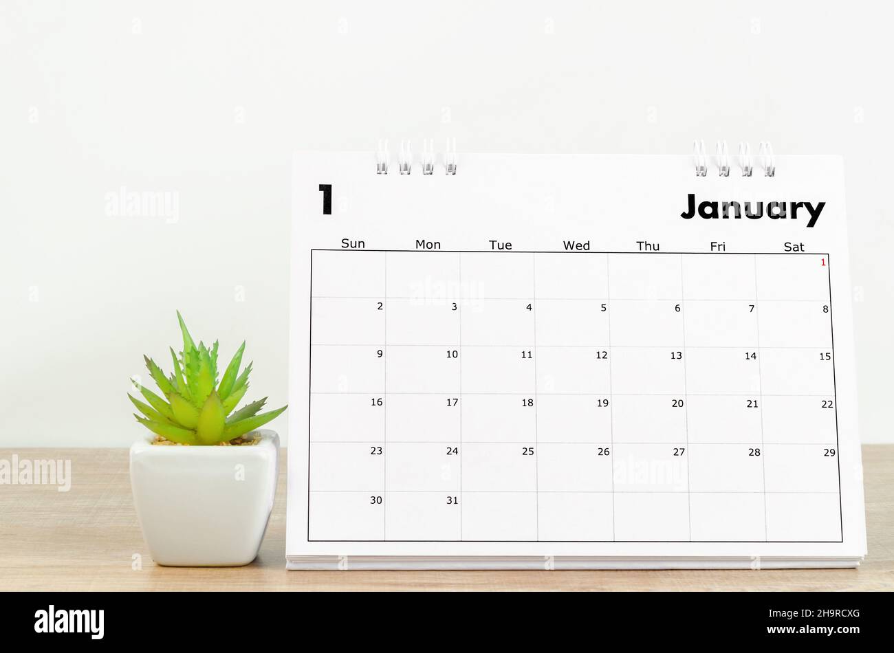The January 2022 desk calendar and small plant on wooden table Stock ...