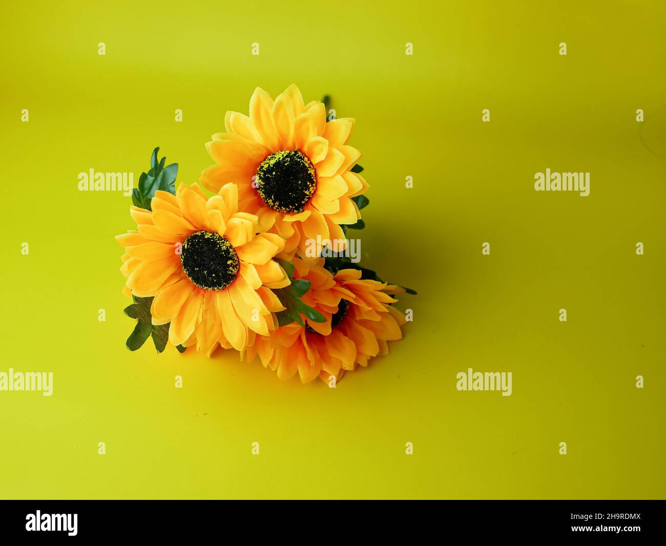 artificial sunflower for decoration isolated on yellow background Stock Photo