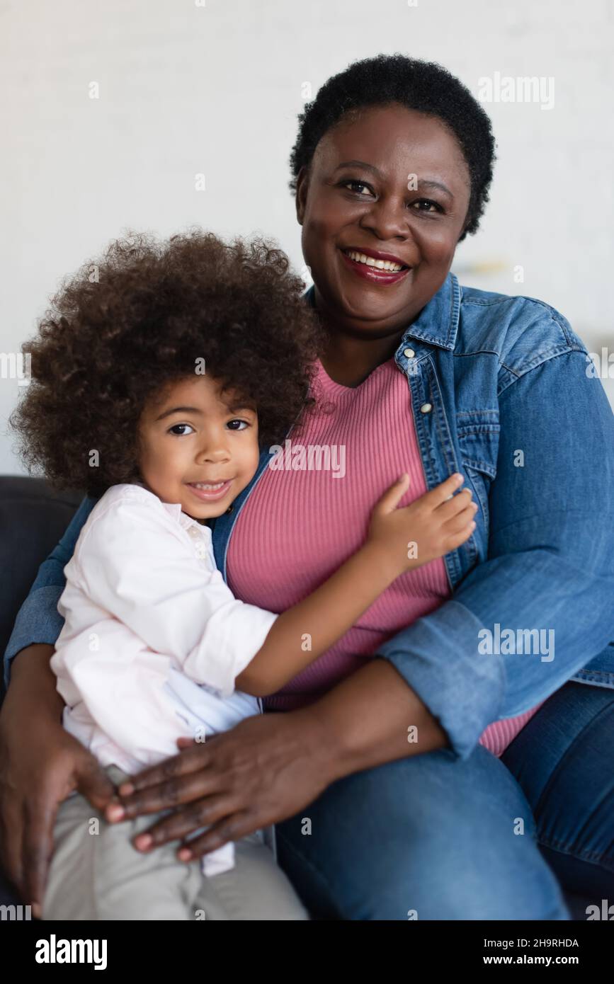 happy african american girl with granny looking at camera while embracing at home Stock Photo