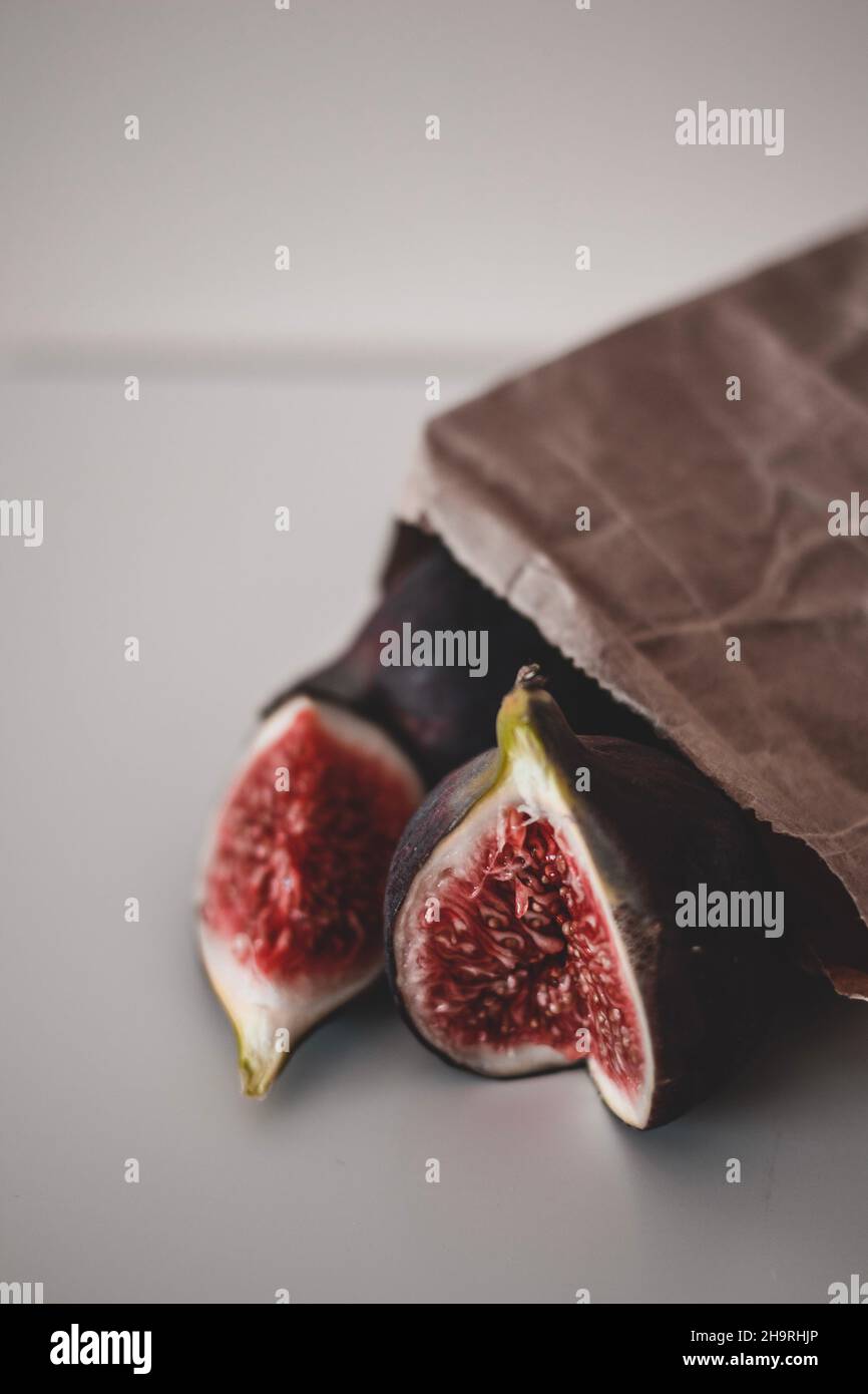 Fresh fruit harvest of ripe figs whole and halved, on the brown craft ...