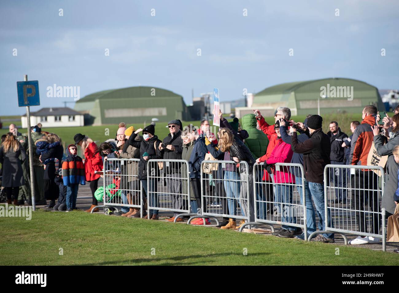 Families await the arrival of  820 Squadron  returning to the air station at RNAS Culdrose, Helston in Cornwall, with their seven Merlin Mk2 helicopters, were around 60 aircrew and engineers from the squadron while the others have returned separately. The Carrier Strike Group 2021 has included nine ships from various allied countries, one submarine, 32 aircraft and more than 3,700 personnel. The deployment has been a significant milestone in establishing the UK's global capability to operate F35 jets as part of the UK's conventional deterrent. Stock Photo