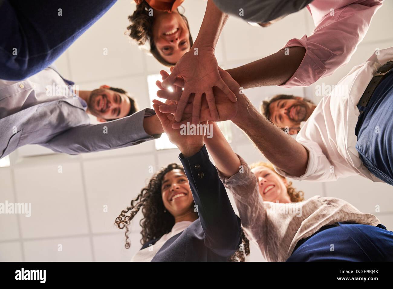 Business people stack hands as a symbol of community and togetherness ...