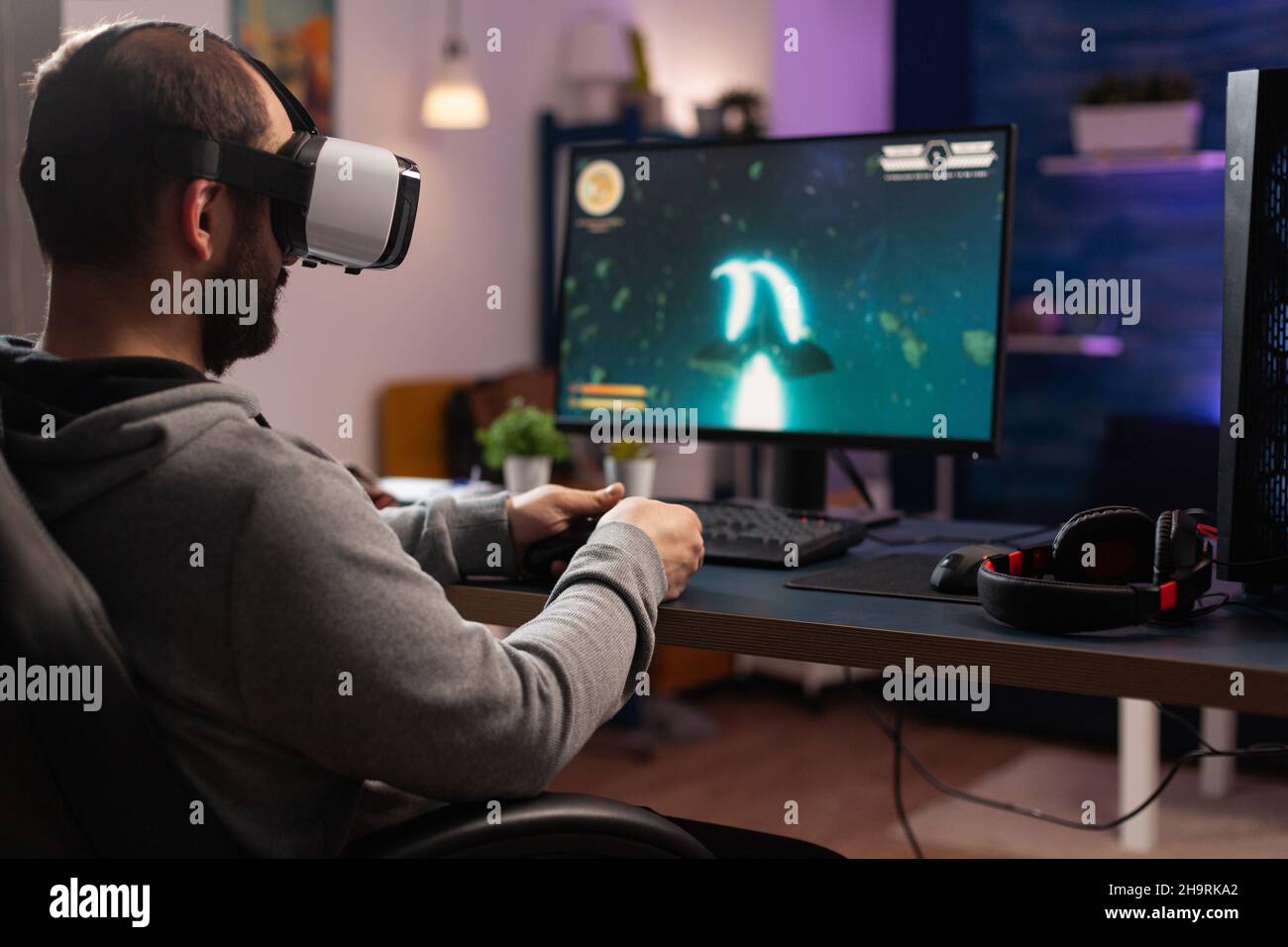 Free Photo  Gamer using controller to play online video games on computer.  man playing game with joystick and headphones in front of monitor. player  having gaming equipment, doing fun activity.