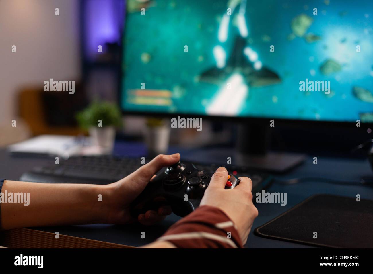 Free Photo  Person playing video games with controller on computer. player  using joystick and wearing headphones to play online game on monitor.  modern man using gaming equipment to have fun.
