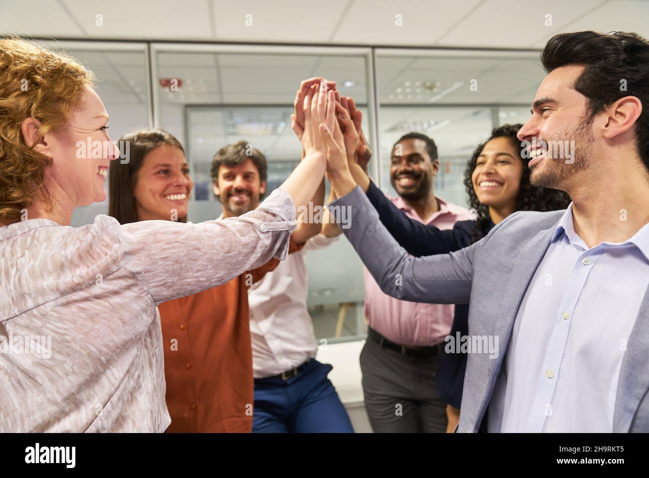 Successful business team makes high five in the office as motivation after a meeting Stock Photo