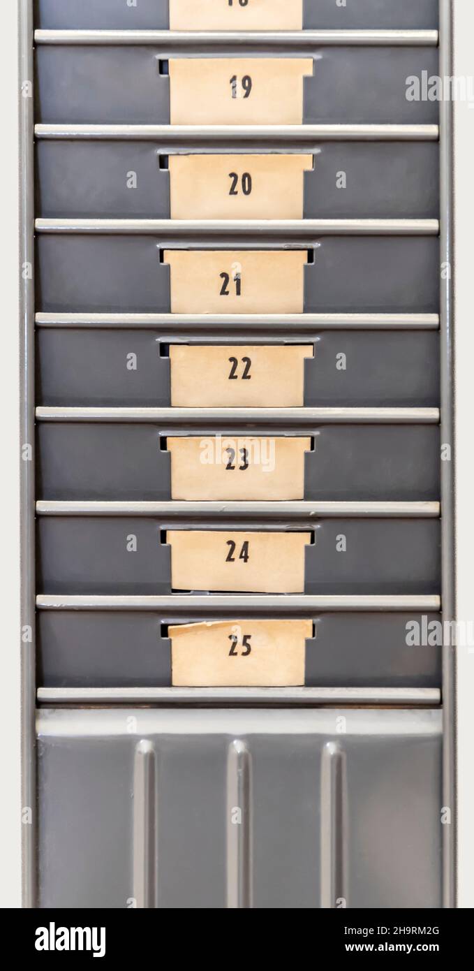 Time clock card rack with number tags. Stock Photo