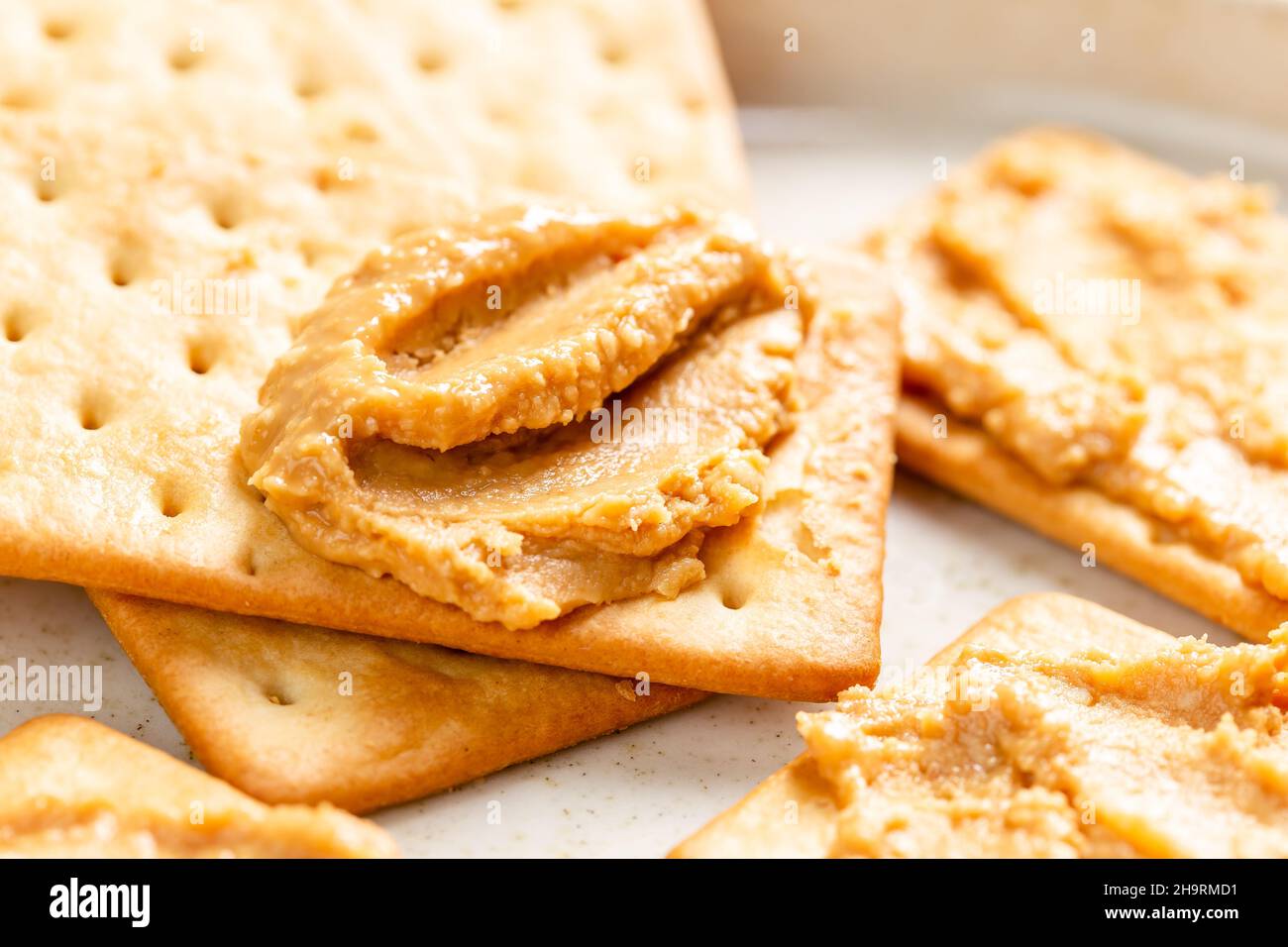 Crunchy peanut butter spread on soda crackers close up Stock Photo Alamy