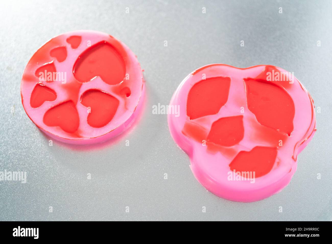 Making hear and kiss shaped chocolate molds with red candy melts Stock