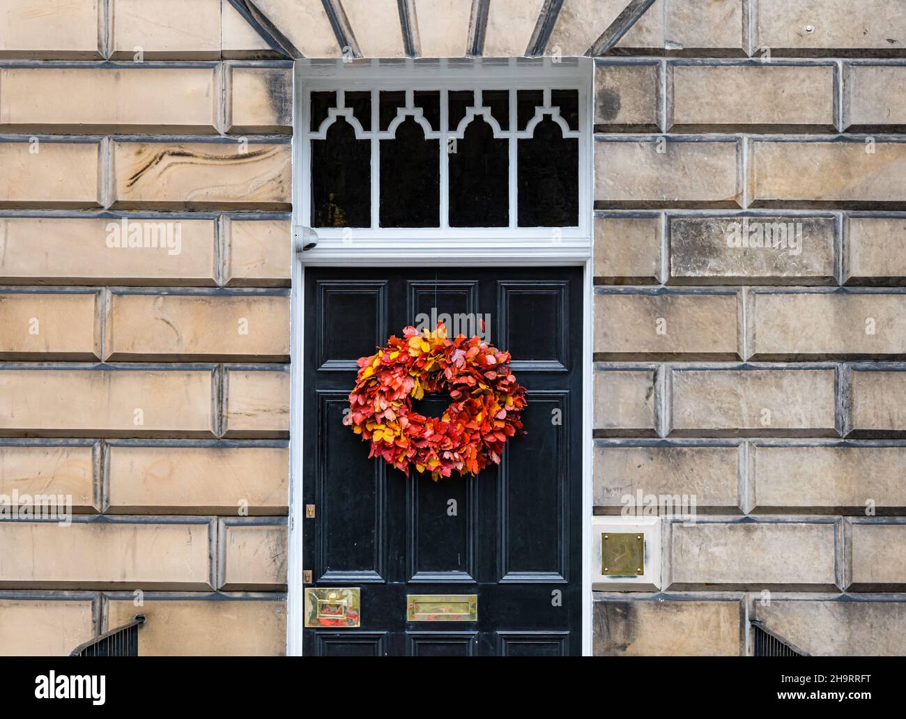townhouse black painted front door with seasonal wreath