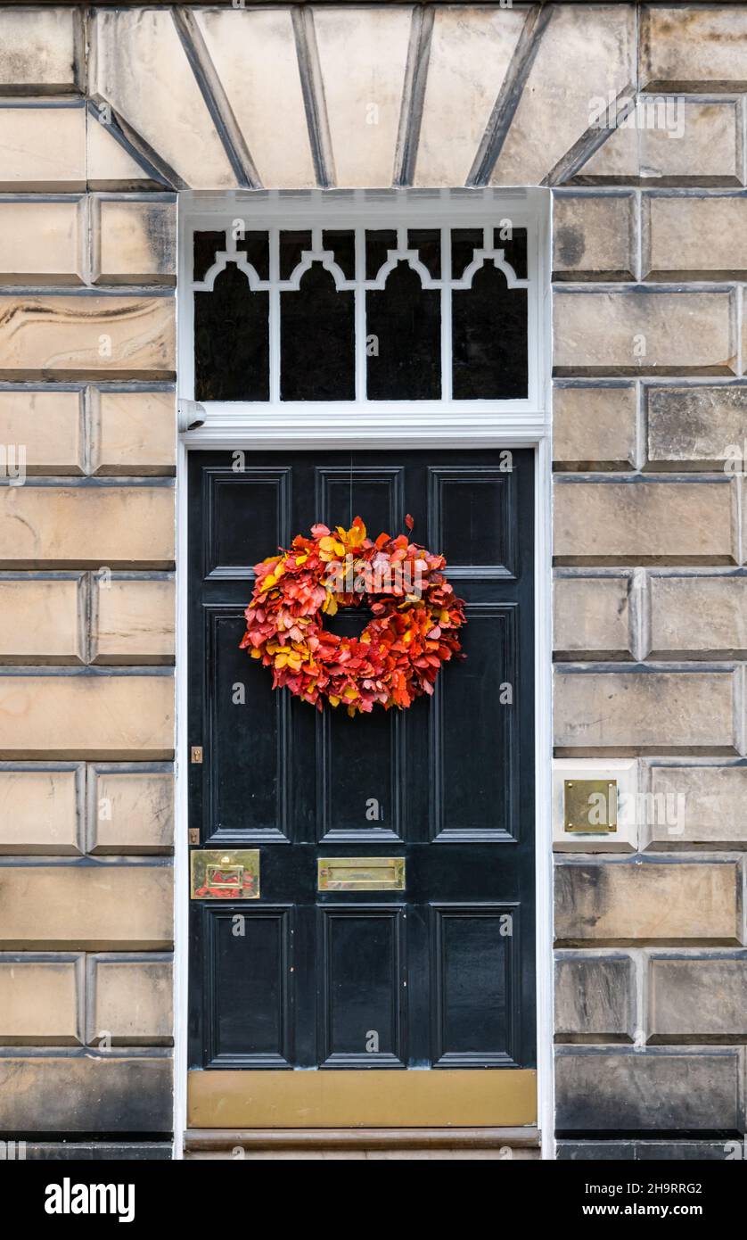townhouse black painted front door with seasonal wreath