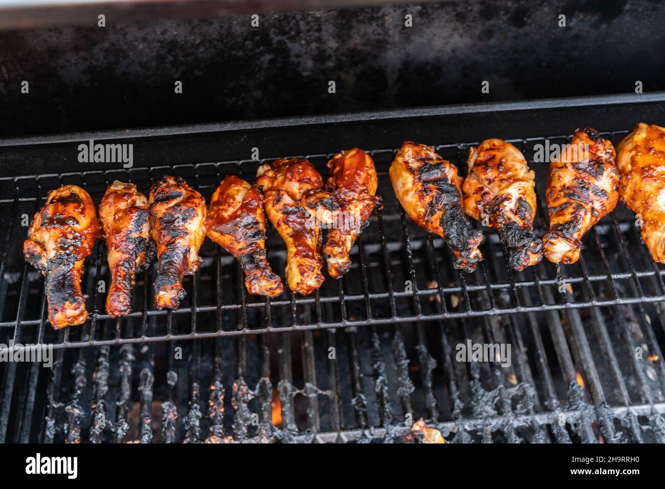 Grilling BBQ chicken drumsticks on outdoor gas grill Stock Photo Alamy