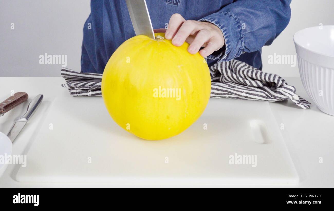 Step by step. Whole golden dewlicious melon on a white background Stock