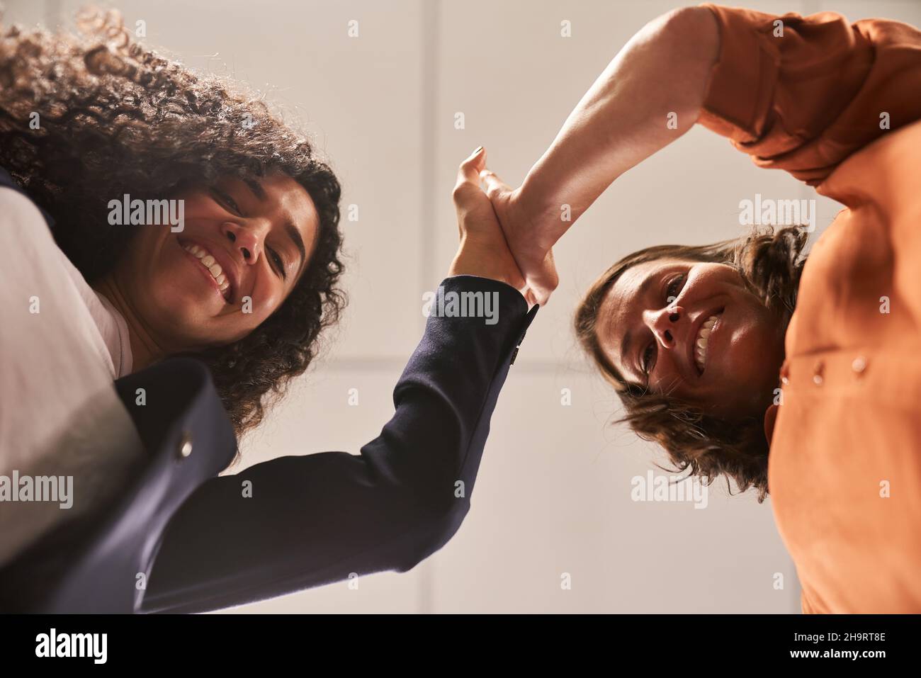 Start-up business founders women give themselves a high five for motivation and success Stock Photo