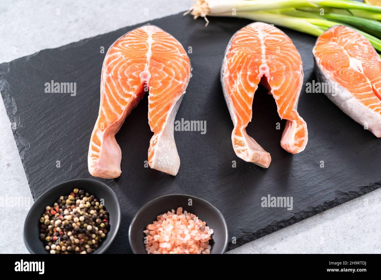 Farm-raised salmon steaks on a slate board Stock Photo - Alamy